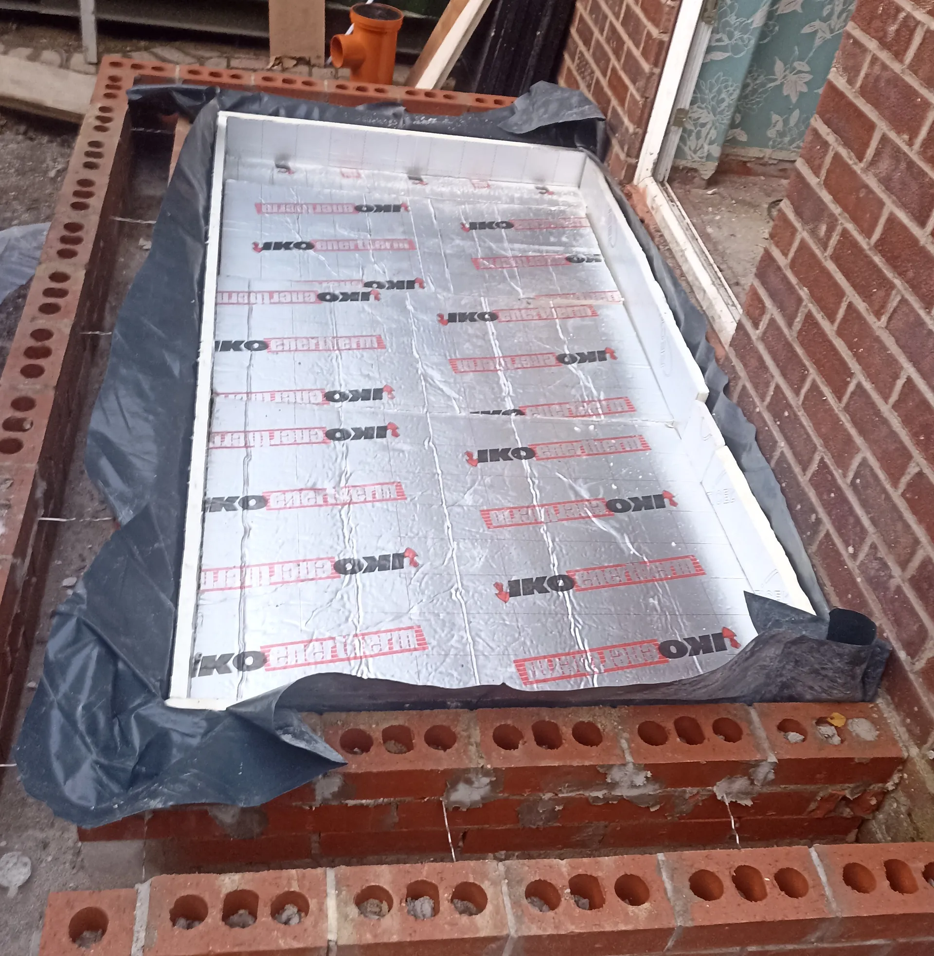 Floor insulation boards fitted within the developing masonry footprint.