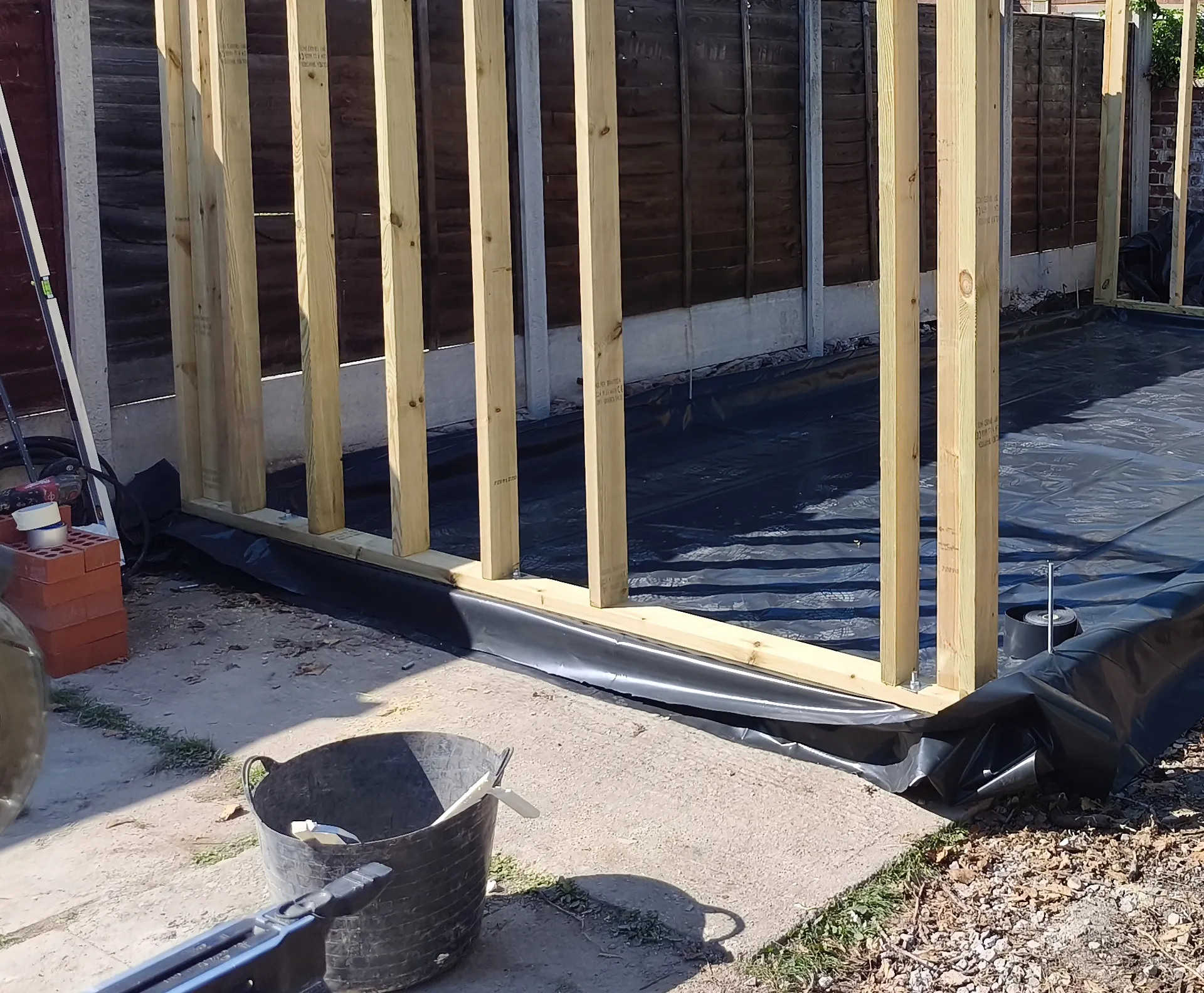 Timber wall framing and floor membrane during garden room construction