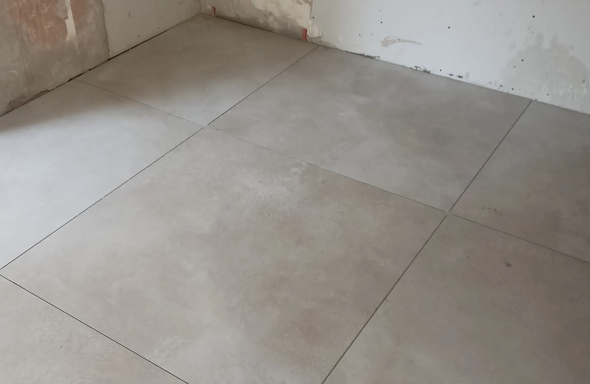 Large-format floor tiles and joint alignment during installation.