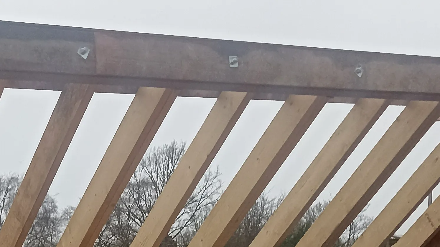 Timber roof framing and ridge-beam detail before enclosure