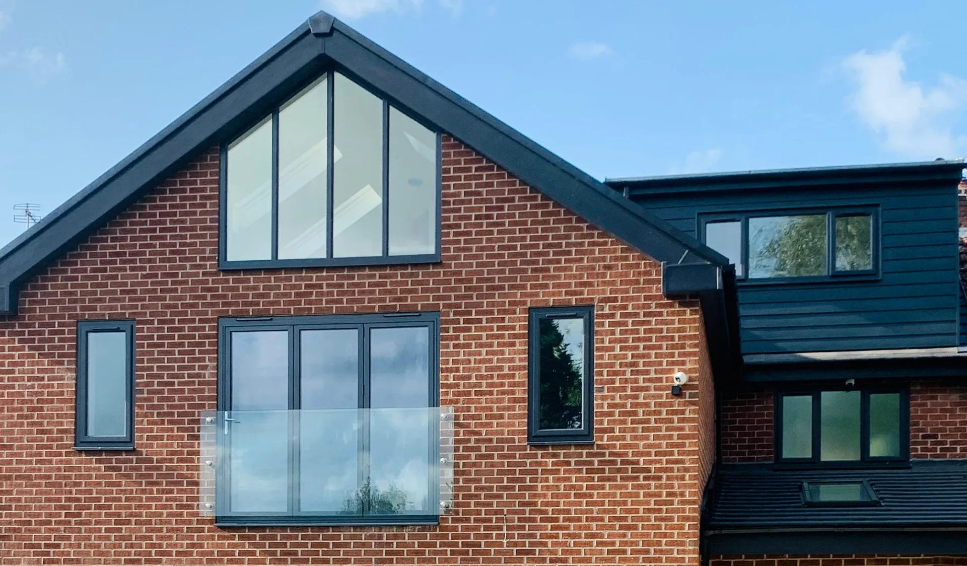Rear gable brickwork, roof detailing and upper-level glazing.