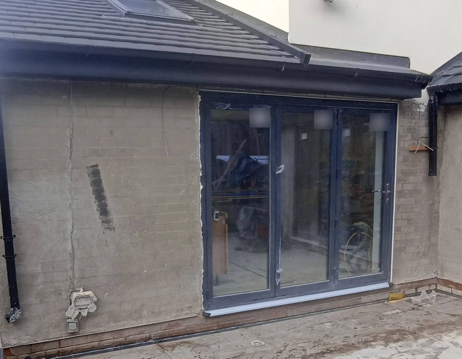 Rear extension with tiled roof and new glazing during external finishing.