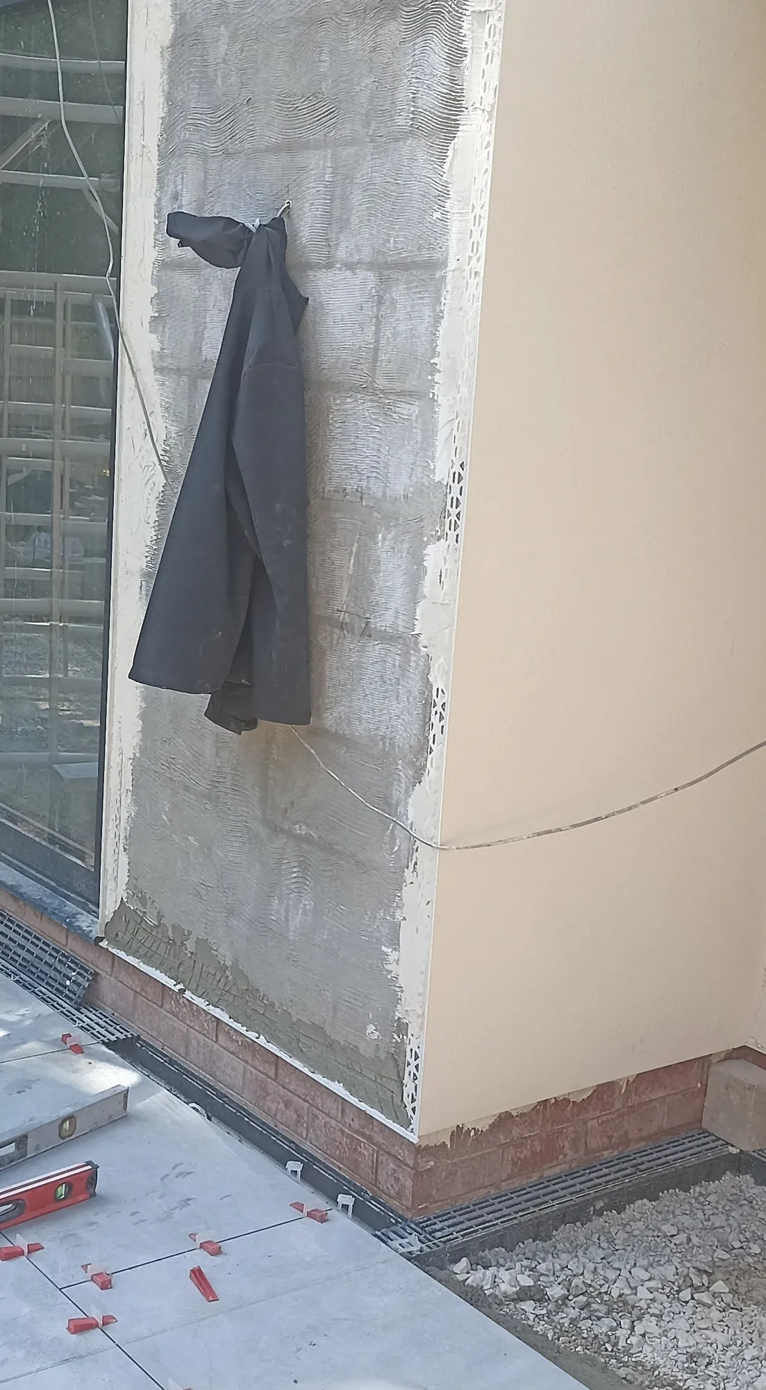 Exterior render being applied around a glazed opening.
