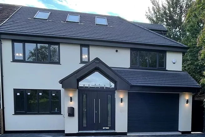 Rendered front elevation with a tiled entrance canopy, dark glazing and the garage door closed.