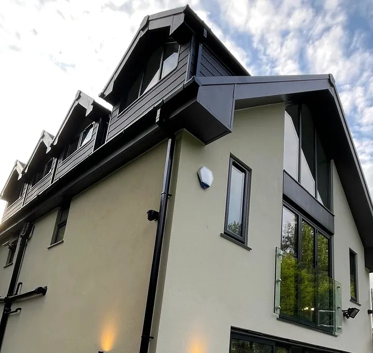 Rendered rear elevation, glazed gable and roof detailing during external finishing.