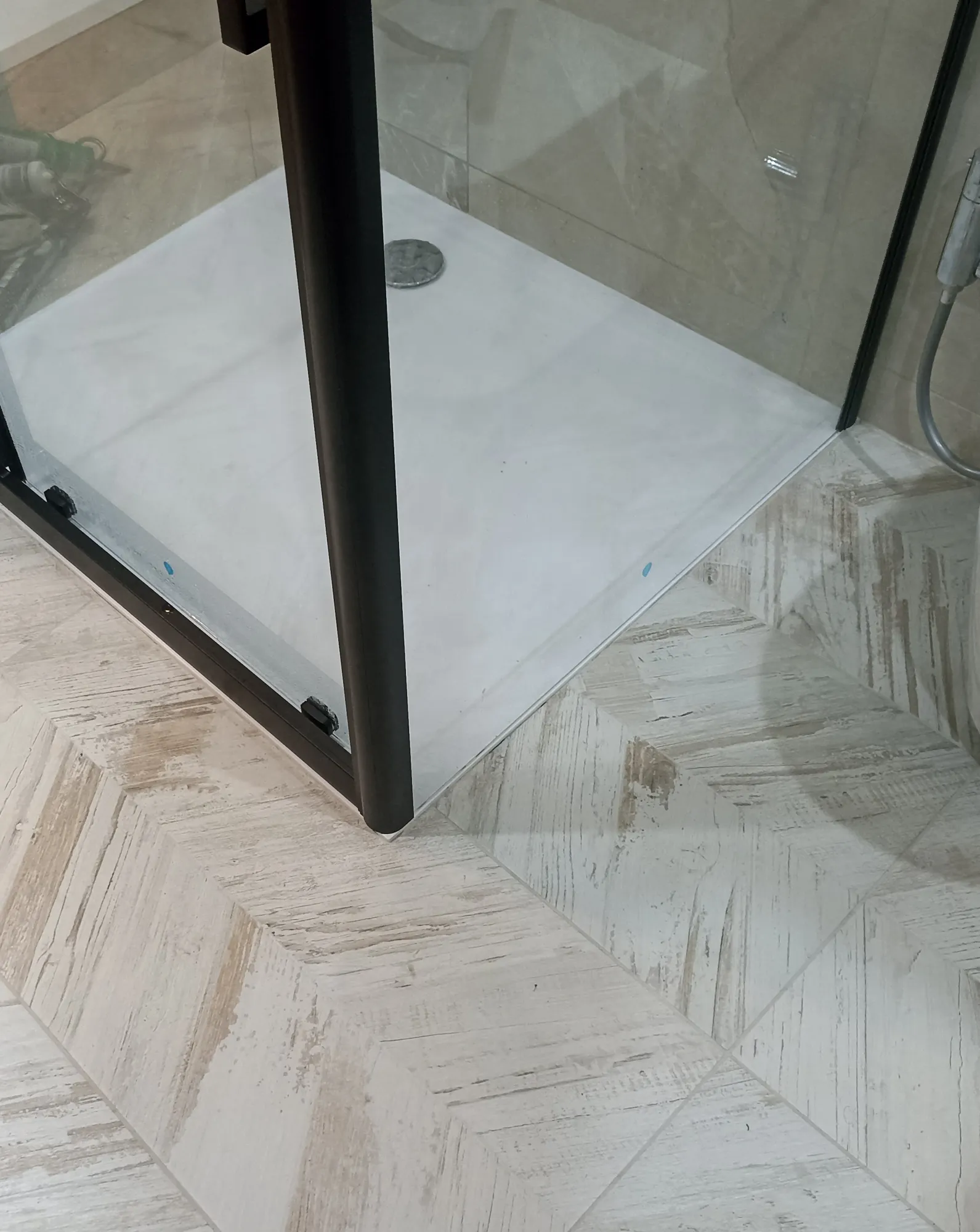 Shower enclosure, tray and patterned floor tiling during fit-out.