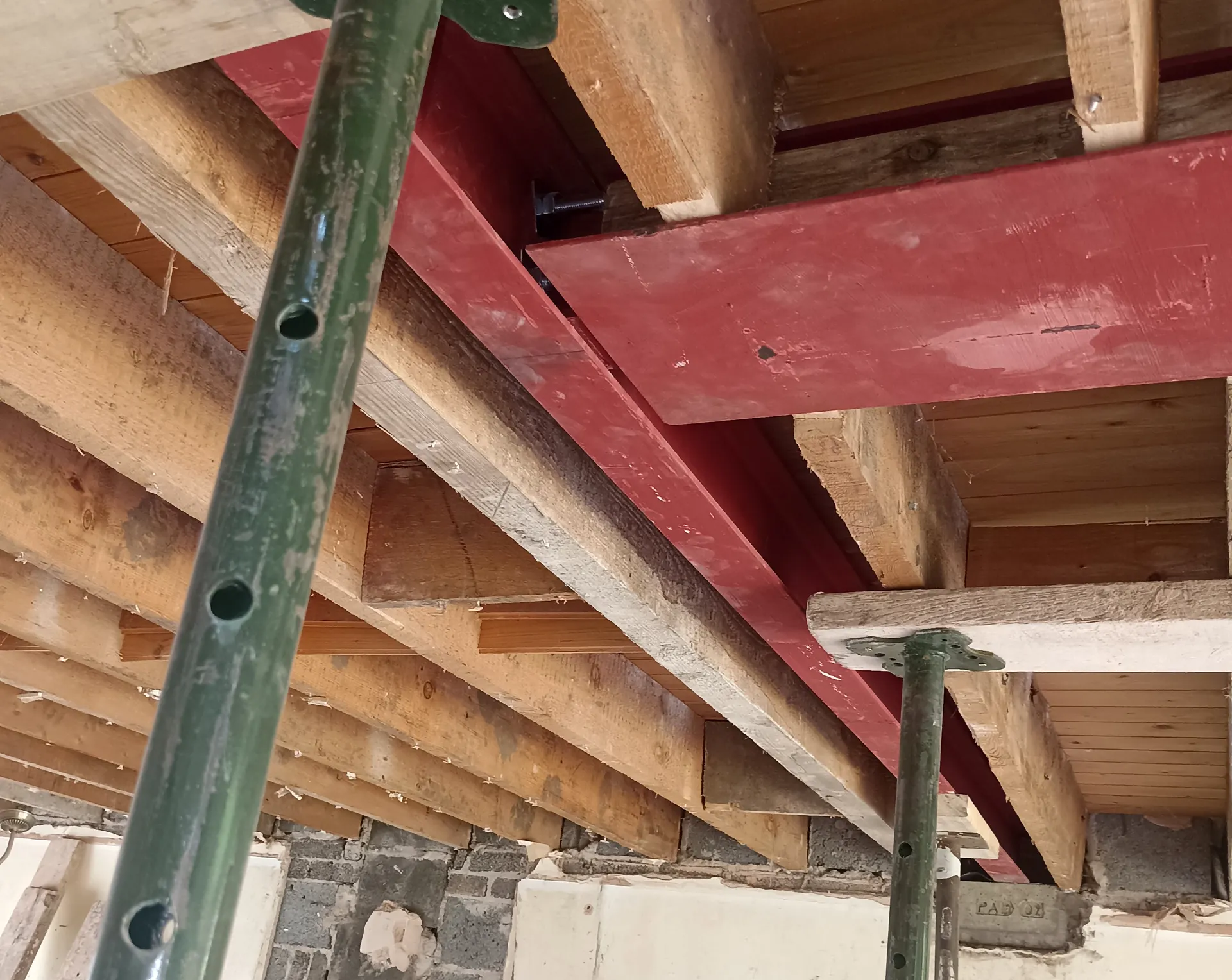 Intersecting steel beams and existing floor joists during temporary support works.